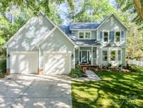 Charming two-story home featuring a two-car garage, manicured lawn, and inviting front porch with classic architectural details at 9920 White Cascade Dr, Charlotte, NC 28269