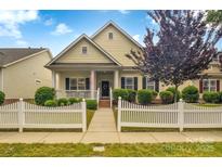 Charming home with a welcoming front porch and manicured landscaping with a picket fence at 1006 Phar Lap Dr, Indian Trail, NC 28079