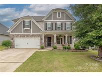 Beautiful two-story home featuring a stone-accented facade, well-manicured lawn, and a two-car garage at 1048 Harbor Bay Dr, Indian Land, SC 29707