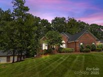 Charming brick home featuring a lush lawn and mature trees, creating a serene and inviting atmosphere at 10501 Mount Olive Dr # 7, Mount Pleasant, NC 28124