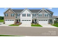 Beautiful townhome exterior with attached garages, manicured lawn, and classic architectural details at 1229 Margo Mannor Dr, Fort Mill, SC 29708