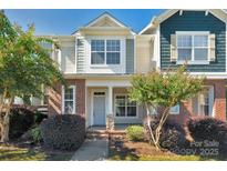 Charming townhome with brick accents, a covered porch, and well-maintained landscaping at 127 Walnut Cove Dr # D, Mooresville, NC 28117