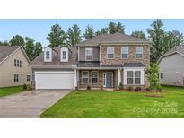 Charming two-story home with a brick and siding facade, a well-manicured lawn, and an attached two-car garage at 1540 Croydon St, Indian Land, SC 29707