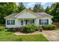Charming single-story home with light siding, blue shutters, and a well-manicured front yard with mature landscaping at 159 Pitts School Nw Rd, Concord, NC 28027