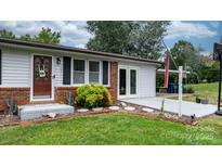 Charming home featuring brick accents, a well-manicured lawn, and a covered parking area at 1691 Hill River Rd, Hiddenite, NC 28636