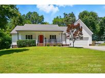 Charming home with a well-manicured lawn and a welcoming red front door at 185 Eastcliff Se Dr, Concord, NC 28025