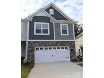 Two-story home featuring a two-car garage, stone accents, gray siding, and well-manicured lawn at 1922 Highland Park Dr, Charlotte, NC 28269