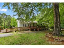 Charming one-story home with ramp access, lush greenery, and a welcoming front porch at 4230 Train Chaser Pl, Indian Land, SC 29707