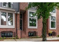 Charming red brick townhome with black-trimmed windows and landscaped front entrance at 428 E 33Rd St, Charlotte, NC 28205
