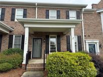 Inviting two-story townhouse features brick facade, black shutters, and lush landscaping at 5476 Ives Nw St, Concord, NC 28027