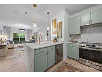 Modern kitchen features marble countertops, a kitchen island, and stainless steel appliances, perfect for cooking and entertaining at 630 Calvert St # 111, Charlotte, NC 28208