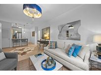 Bright living room featuring hardwood floors, modern lighting, and stylish decor at 630 Calvert St # 111, Charlotte, NC 28208