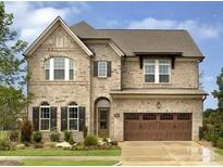Beautiful two-story brick home with manicured lawn and an attached two-car garage under a canopy at 6510 Honeymeade Cir, Charlotte, NC 28277