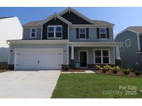 Charming two-story home featuring a manicured lawn, attached two car garage, and inviting front porch at 8610 Acadia Pkwy, Sherrills Ford, NC 28673
