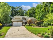 Charming home with a stone and siding exterior, attached garage, and well-manicured lawn at 1009 Jerry Ln, Matthews, NC 28105