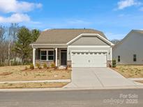 Charming single-story home featuring stone accents, neutral siding, and an attached two-car garage at 1074 Bull Dog Ln, Wingate, NC 28174