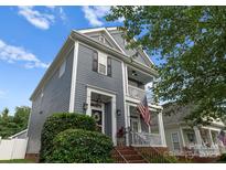 Charming two-story home with a welcoming porch and an American flag displayed at 14034 Holly Springs Dr, Huntersville, NC 28078