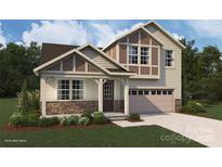 Charming two-story home with stone accents, landscaped yard, and attached two-car garage at 1441 Mccollum St, Monroe, NC 28112
