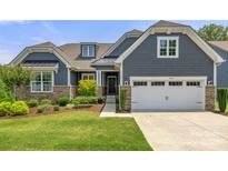 Charming home featuring a manicured lawn, stone accents, gray siding, and an attached two-car garage at 1467 Tranquility Blvd, Lancaster, SC 29720