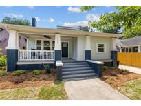 Charming front porch of light blue home with brick accents and well manicured landscaping at 1922 Thomas Ave, Charlotte, NC 28205