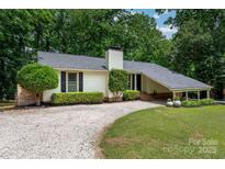 Charming single-story home with a gravel driveway, manicured lawn, and mature trees at 2298 Wintercrest Dr, Rock Hill, SC 29732