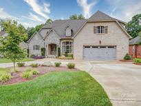 Stunning home showcasing manicured landscaping, a stone and brick facade, and a three-car garage at 4025 Foxes Trl, Cramerton, NC 28032