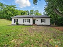 Charming one-story home featuring white brick, black shutters, and a well-manicured front yard at 419 Wade St, Wadesboro, NC 28170