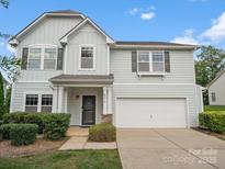 Charming two-story home featuring light blue siding, a two-car garage, and well-manicured landscaping at 4576 Fox Ridge Ln, Fort Mill, SC 29707