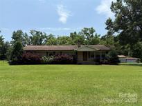 Charming brick home with a well-maintained lawn, mature trees, and lush landscaping, offering great curb appeal at 6018 Unionville Rd, Monroe, NC 28110