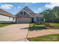 Charming home featuring stone accents, a two-car garage, and professionally landscaped front yard at 608 Latrobe Dr, Iron Station, NC 28080