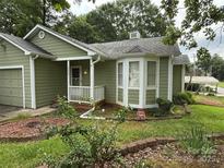 Charming single-story home with green siding, white trim, landscaped yard, and covered front porch at 6300 Fox Hunt Rd, Indian Trail, NC 28079