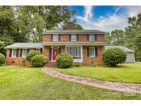 Charming brick two-story home with a landscaped front yard and a welcoming red front door at 1010 Forest Dr, Lancaster, SC 29720