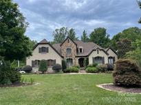 Charming two-story home featuring a stone facade, manicured lawn, and lush landscaping under a cloudy sky at 1032 Seminole Dr, Waxhaw, NC 28173