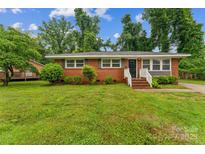 Charming single-story brick home with manicured lawn and inviting entrance, showcasing classic curb appeal at 1631 Vancouver Dr, Charlotte, NC 28213
