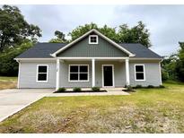 Charming gray home featuring a covered front porch with stately columns and a well-manicured lawn at 212 Queens Ct, Gastonia, NC 28052