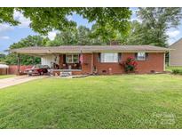 Charming brick home with a well-manicured lawn, classic car, and inviting front porch at 2210 Joes Lake Rd, Shelby, NC 28152