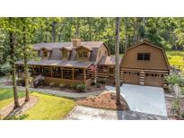 Inviting log home features an expansive covered porch and a detached two-car garage at 2709 Blythe Rd, Waxhaw, NC 28173