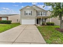 Charming two-story home featuring a well-maintained lawn and a convenient attached two-car garage at 673 Shellbark Dr, Concord, NC 28025