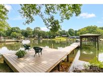 Inviting waterfront dock with seating, lush greenery, and picturesque lake views perfect for relaxation at 7232 Executive Cir, Denver, NC 28037