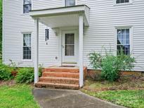 Inviting front entryway featuring brick steps, a covered porch, and a classic white door with charming details at 7317 Red Branch Ln, Charlotte, NC 28226