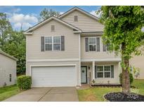 Charming two-story home with gray shutters, vinyl siding, manicured lawn and two-car garage at 9524 Eagle Feathers Dr, Charlotte, NC 28214
