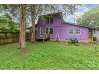 Charming purple home with a cozy backyard, small deck, and lush green lawn at 10 Cedarvilla Dr, Rock Hill, SC 29730