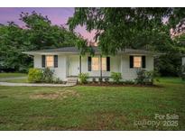 Charming single-story home featuring manicured landscaping and a classic white exterior at 107 S Branch St, Monroe, NC 28112