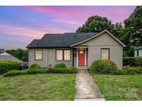 Charming bungalow featuring a well-kept lawn, beautiful landscaping, and eye-catching red front door, ideal for a starter home at 1125 Bethel Rd, Charlotte, NC 28208