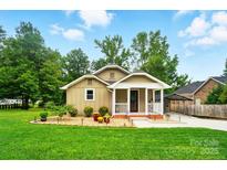 Charming home with a covered front porch, landscaped yard, and lush green lawn at 1209 Rainbow Dr, Kannapolis, NC 28081