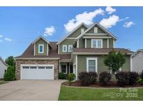 Inviting two-story home featuring a stone-accented garage and a beautifully landscaped front yard at 1244 Weir Ct, Fort Mill, SC 29708