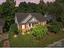 Beautiful brick home featuring a well-manicured lawn and vibrant landscaping at 1525 Valhalla Dr, Denver, NC 28037
