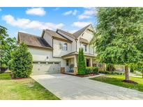 Beautiful two-story home with a two-car garage and manicured landscaping on a sunny, partially cloudy day at 15344 Cimarron Hills Ln, Charlotte, NC 28278