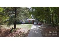 Charming single-story home with a long driveway, mature trees, and well-maintained front yard landscaping at 2930 Sheets Cir, Charlotte, NC 28214