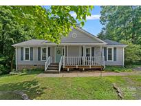 Charming single-story home with gray siding, a front porch, and lush green landscaping at 2934 Drakes Crossing Dr, Charlotte, NC 28262